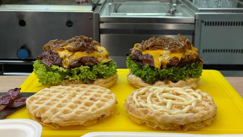 Waffel Cheese Burger mit karamellisierten Zwiebeln, Salat und Tomate